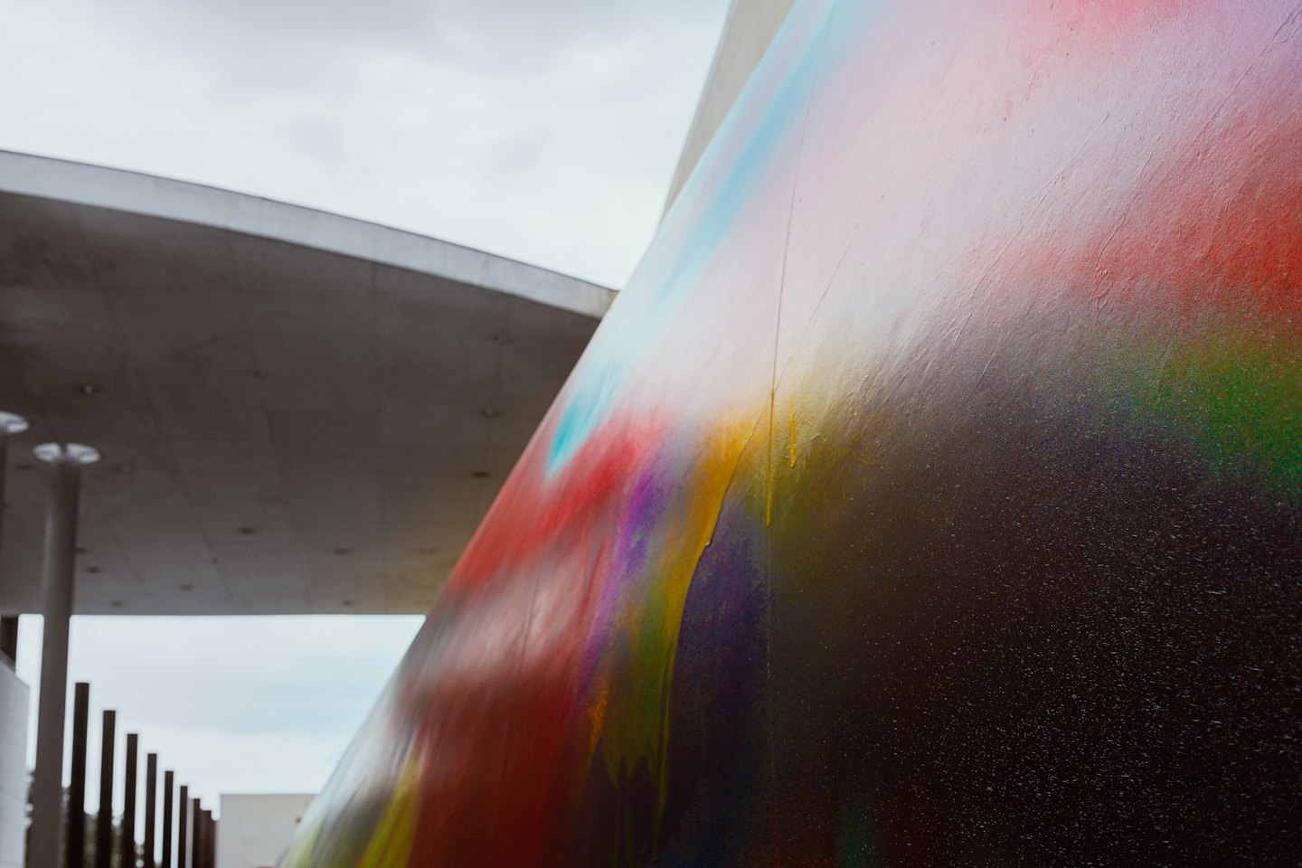 Un muro di cemento moderno coperto da un'arte astratta di vernice spray.