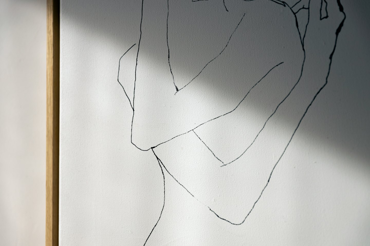 Minimalista disegno a linea nera di forme umane su tela bianca.